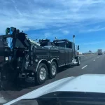 A black tow truck on a road