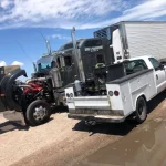 a truck with a tractor trailer parked on the side of the road